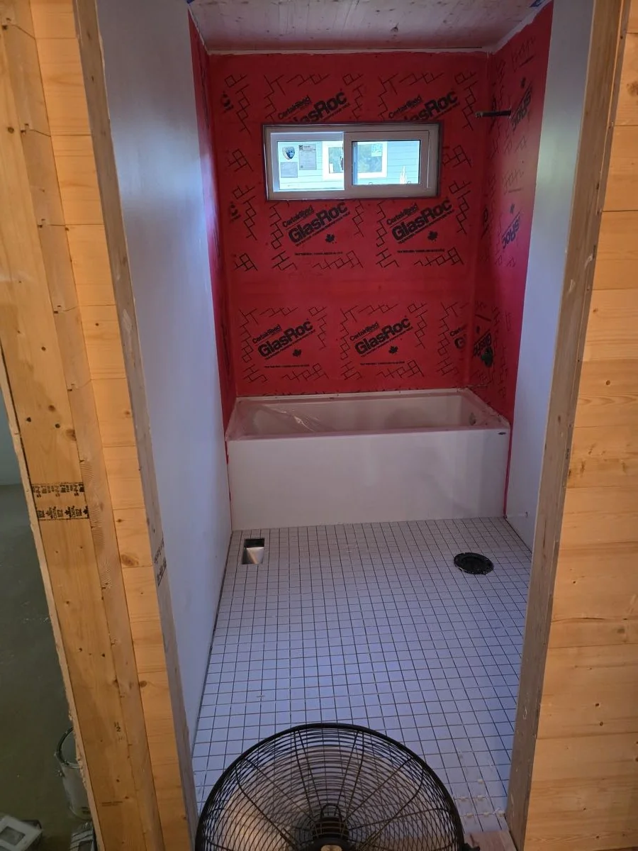 Bathroom stripped to studs with new tub surround and vapour barrier in place