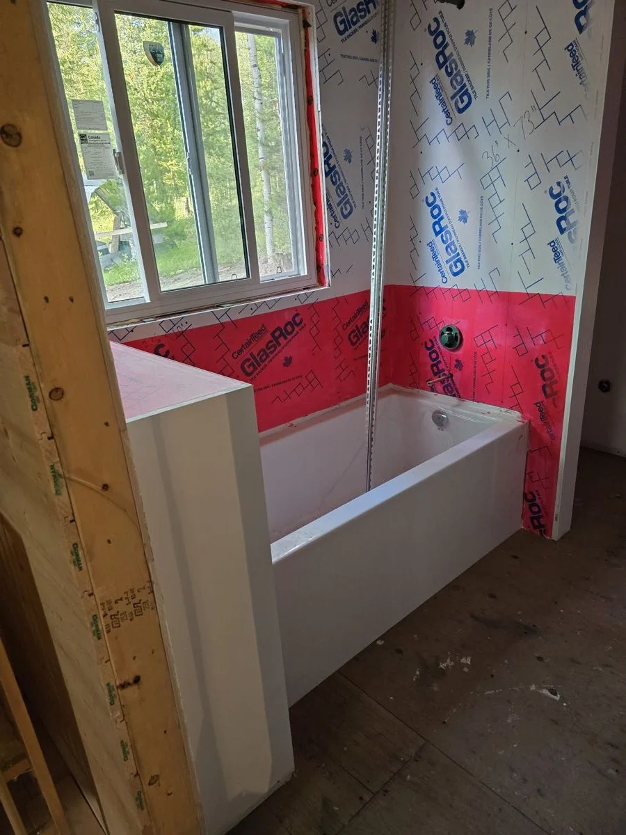 New bathtub set in a framed bathroom with insulation and vapour barrier