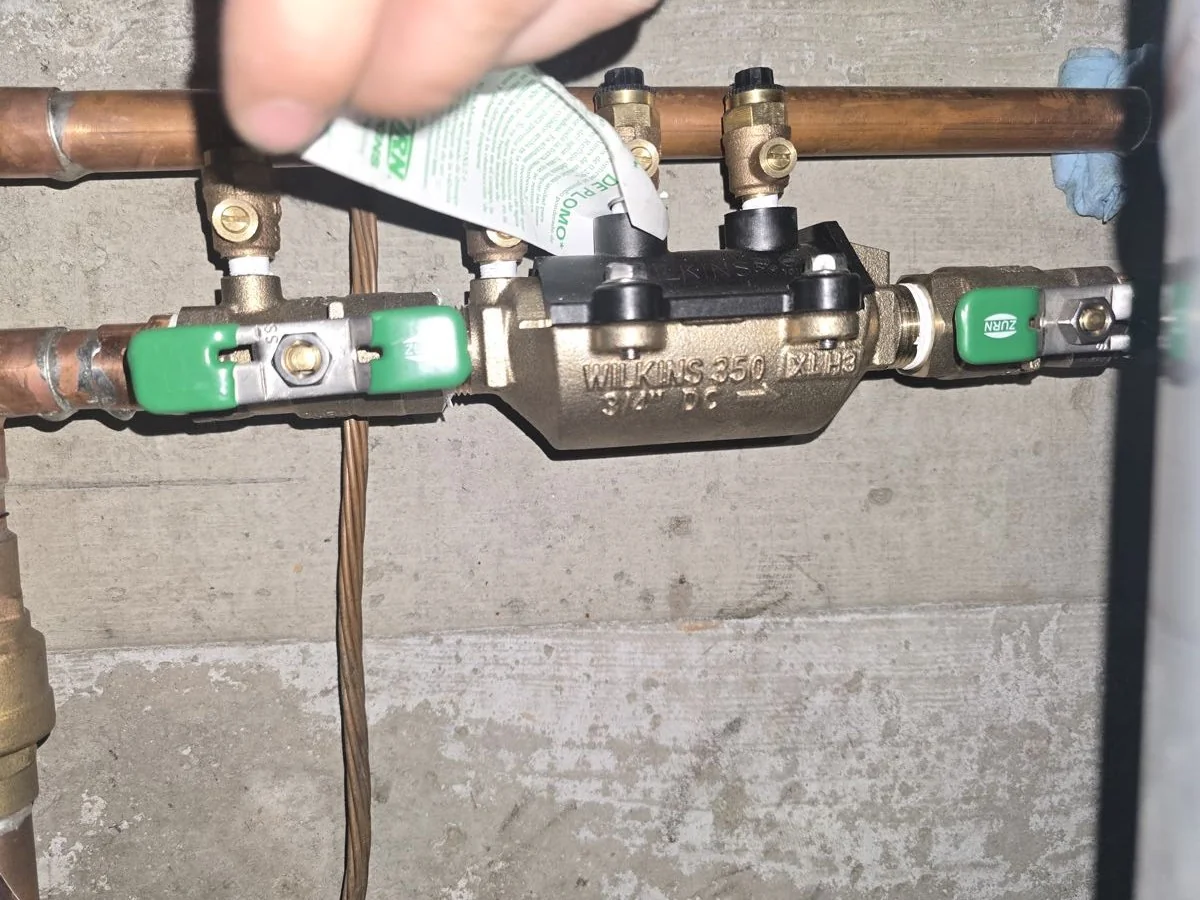 Copper pipework and valve assembly installed on a basement wall