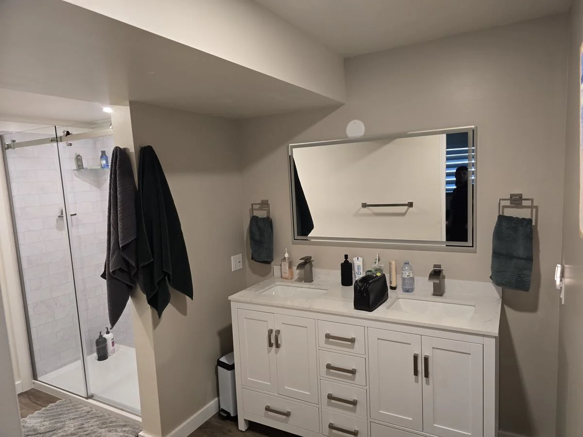 Finished bathroom with glass shower, double vanity and mirror