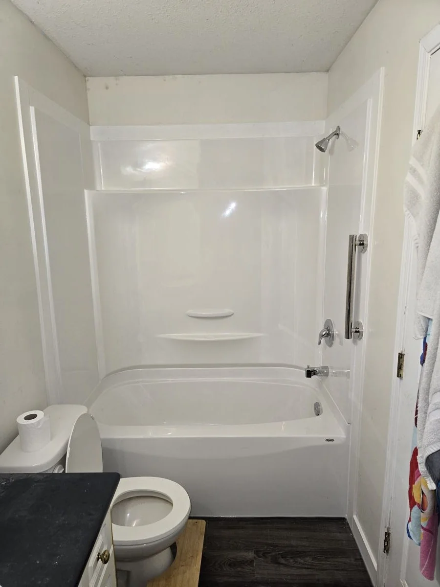 New tub and shower unit installed in a compact bathroom