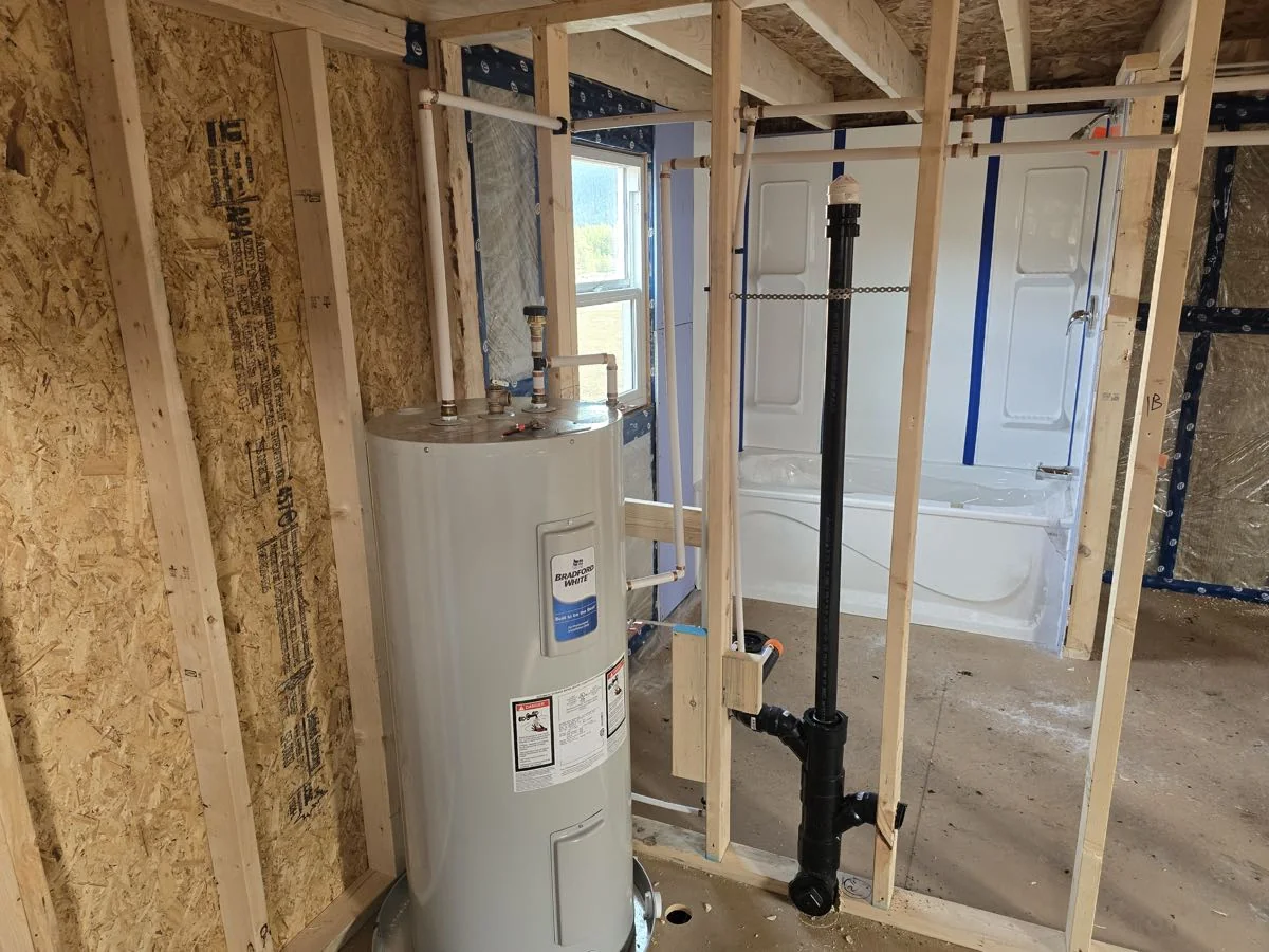 New hot water tank set in place during a framed rough-in