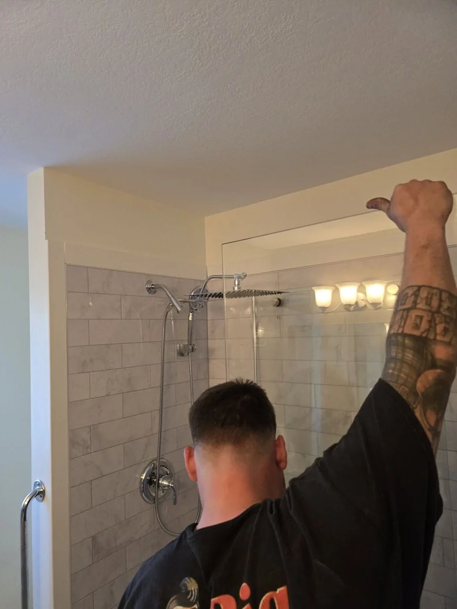 Tile being installed in a shower during a bathroom renovation