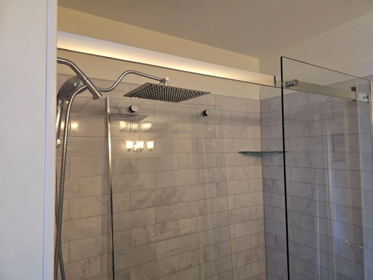 Finished tiled shower with glass panel and rainfall head