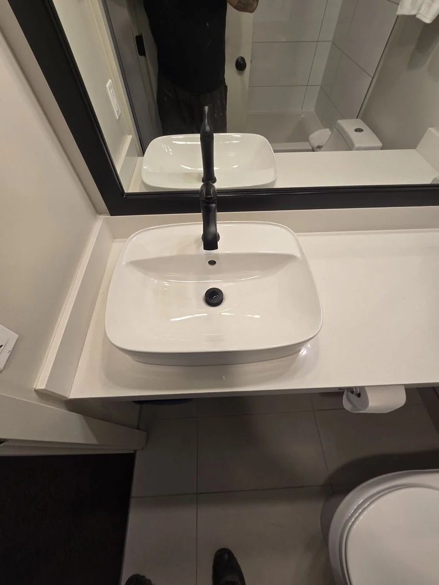 Completed bathroom vanity with black tapware and framed mirror