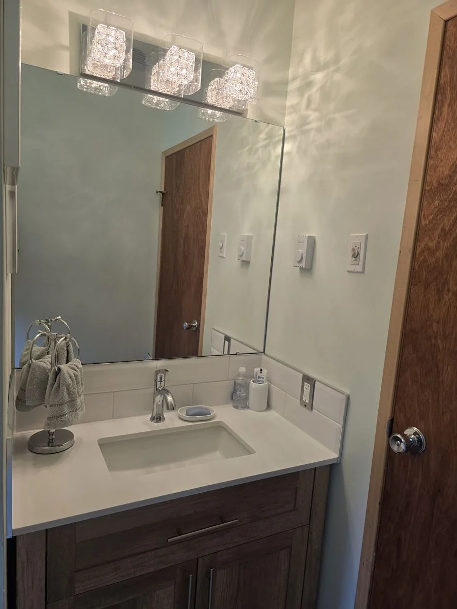 Finished bathroom with vanity, mirror and modern light fixtures