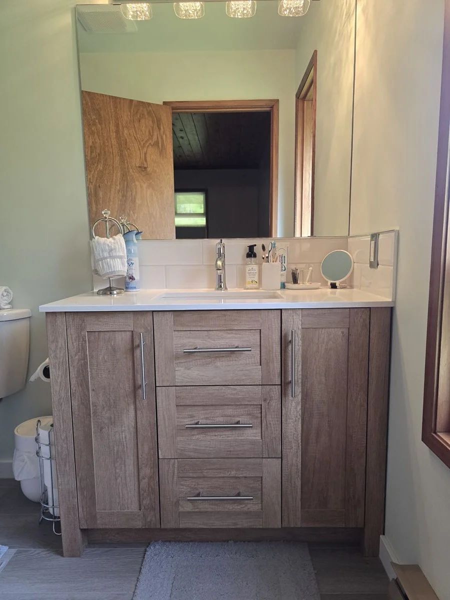 Completed bathroom renovation with vanity and mirror