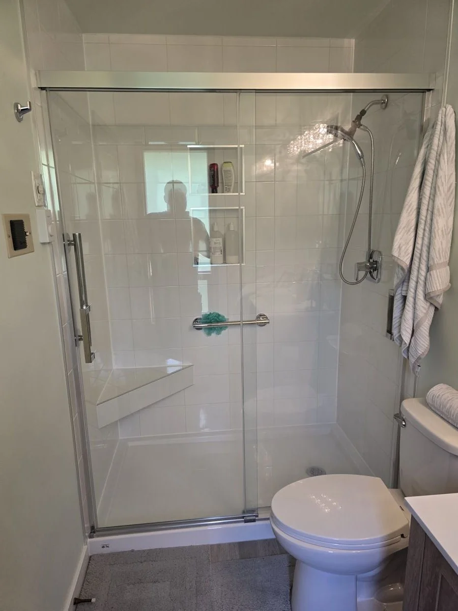 Finished bathroom with glass shower, niche shelving and toilet